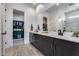 Modern bathroom with double vanity, quartz countertops, and a glass-enclosed shower at 7694 W Desert Spoon Dr, Peoria, AZ 85383