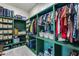 Walk-in closet with custom green shelving, providing ample storage for clothes, baskets, and luggage at 7694 W Desert Spoon Dr, Peoria, AZ 85383