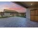 Relaxing covered patio with stone floors, a water feature, and views of the landscaped backyard at 7694 W Desert Spoon Dr, Peoria, AZ 85383