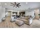 Open-concept living area with tile floors, comfortable seating, a ceiling fan, and natural light at 7694 W Desert Spoon Dr, Peoria, AZ 85383