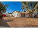 Expansive backyard featuring mature trees, covered patio, and a well-maintained exterior at 7737 W Cherry Hills Dr, Peoria, AZ 85345