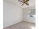 Bedroom with a ceiling fan, window, neutral carpet, and a bright neutral-toned wall at 7737 W Cherry Hills Dr, Peoria, AZ 85345