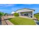 View of landscaped backyard with artificial grass, gravel, patio and outdoor kitchen at 7751 W Forest Grove Ave, Phoenix, AZ 85043