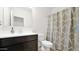 This bathroom showcases a vanity with a faucet and a tiled shower behind a curtain at 7751 W Forest Grove Ave, Phoenix, AZ 85043