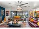 Bright living room with large windows providing backyard views, a ceiling fan, and cozy furniture at 8009 W Northview Ave, Glendale, AZ 85303