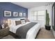 Serene main bedroom featuring an accent wall, plush bedding, and a view to the window at 8149 E Petunia Ave # 1041, Mesa, AZ 85212