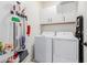 The laundry room features a washer and dryer set along with storage cabinets and wall-mounted cleaning supplies at 8188 N 22Nd Dr, Phoenix, AZ 85021