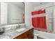 Bathroom featuring granite counters, a single sink vanity, and a shower-tub combination with red shower curtain at 9313 S 39Th Dr, Laveen, AZ 85339