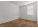 Empty, carpeted bedroom with white walls and one window providing natural light at 9313 S 39Th Dr, Laveen, AZ 85339