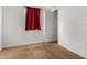 Cozy bedroom featuring neutral carpet, white walls, and a window with a red curtain at 9313 S 39Th Dr, Laveen, AZ 85339