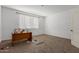 Neutral bedroom with carpet and a large window providing plenty of natural light, and a door at 9313 S 39Th Dr, Laveen, AZ 85339