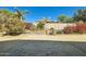 The backyard features colorful plants along the block wall, manicured landscape and brick-paved patios at 9590 W Bajada Rd, Peoria, AZ 85383