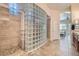 Bathroom showcasing a glass block shower, tile surround, and access to the main bedroom at 9590 W Bajada Rd, Peoria, AZ 85383