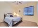 Cozy bedroom featuring a ceiling fan, carpeted floor, and natural light from the window at 9590 W Bajada Rd, Peoria, AZ 85383