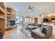 Open-concept living room featuring a stone fireplace, tile floors, and a large sectional sofa at 9590 W Bajada Rd, Peoria, AZ 85383