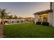 Expansive backyard featuring a lush lawn, inviting pool, and covered patio, perfect for outdoor living at 9937 E Harvest Rd, Florence, AZ 85132