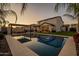 This backyard features a pool, outdoor living area, palm trees, and a green lawn at 9937 E Harvest Rd, Florence, AZ 85132