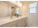 This double-vanity bathroom is well-lit with attractive gold sconces and has a large, decorative mirror at 9937 E Harvest Rd, Florence, AZ 85132