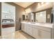 Bathroom with double vanity, large mirror, and view to the main bedroom at 9937 E Harvest Rd, Florence, AZ 85132