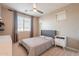 This well-lit bedroom has neutral walls and a ceiling fan, with curtains framing the window at 9937 E Harvest Rd, Florence, AZ 85132