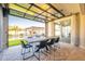 Open-concept dining area with a view of the backyard pool and patio through a retractable glass wall at 9937 E Harvest Rd, Florence, AZ 85132