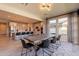 Open-concept dining area with modern light fixtures, an expansive dining table, and views to the kitchen at 9937 E Harvest Rd, Florence, AZ 85132