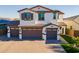 Attractive two-story home with a three-car garage, a tile roof, and a manicured lawn on a sunny day at 9937 E Harvest Rd, Florence, AZ 85132