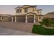 Exterior shot of home featuring a three-car garage, well-manicured lawn, and inviting front entrance at 9937 E Harvest Rd, Florence, AZ 85132