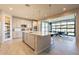 Spacious kitchen with an island, white cabinetry, stainless steel appliances, and an open layout to the dining room at 9937 E Harvest Rd, Florence, AZ 85132