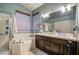 Beautiful bathroom with a soaking tub, dual sinks, and dark wood vanity at 11538 W Laurelwood Ln, Avondale, AZ 85392