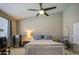 Well-lit bedroom featuring a ceiling fan, comfortable bedding, and stylish decor at 11538 W Laurelwood Ln, Avondale, AZ 85392