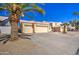 Attractive home exterior with a three-car garage, desert landscaping, and palm tree at 11538 W Laurelwood Ln, Avondale, AZ 85392