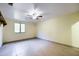 Large bedroom features tiled floors, a ceiling fan, and a window allowing natural light at 1235 E Clearview Dr, Casa Grande, AZ 85122