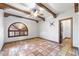 Bonus room featuring tiled floors, a unique arched window, and wood beam architectural details at 1235 E Clearview Dr, Casa Grande, AZ 85122