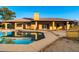 Backyard pool reflects the house, with a covered patio, beautiful pavers, and a well manicured yard at 1235 E Clearview Dr, Casa Grande, AZ 85122