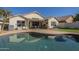 Backyard featuring a pool, patio with outdoor kitchen, and seating area, ideal for outdoor entertaining at 12901 W Wilshire Dr, Avondale, AZ 85392