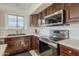 Close-up of a kitchen with stainless steel appliances and dark wood cabinets at 12901 W Wilshire Dr, Avondale, AZ 85392