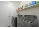 Functional laundry room with modern washer and dryer, plus overhead shelving at 12901 W Wilshire Dr, Avondale, AZ 85392
