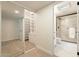 Hallway view of a sleek bathroom with marble floors and glass shower with black trim at 12946 W Maplewood Dr, Sun City West, AZ 85375
