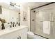 Bathroom vanity with white countertops, black hardware, and a glass shower with marble tile at 12946 W Maplewood Dr, Sun City West, AZ 85375