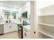 Well-lit kitchen featuring stainless steel appliances, quartz countertops, modern white cabinetry, and open shelving at 12946 W Maplewood Dr, Sun City West, AZ 85375