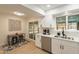Bright kitchen features stainless steel appliances, white cabinetry, and a dining nook with modern accents at 12946 W Maplewood Dr, Sun City West, AZ 85375