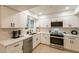 Modern, bright kitchen showcasing white cabinetry, stone countertops, and stainless appliances at 12946 W Maplewood Dr, Sun City West, AZ 85375