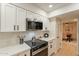 Updated kitchen boasts stainless appliances, quartz countertops, modern white cabinetry and a view into the dining room at 12946 W Maplewood Dr, Sun City West, AZ 85375