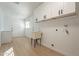Laundry room with lots of storage, folding counter and flooring at 12946 W Maplewood Dr, Sun City West, AZ 85375