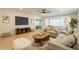 Bright living room includes a large TV, comfortable sofas, and stylish wood flooring at 12946 W Maplewood Dr, Sun City West, AZ 85375