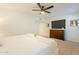 Bright main bedroom with carpet, ceiling fan, dresser, and neutral decor at 12946 W Maplewood Dr, Sun City West, AZ 85375