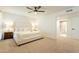 Spacious and cozy main bedroom features carpet, a ceiling fan, and an ensuite bathroom with a glass enclosed shower at 12946 W Maplewood Dr, Sun City West, AZ 85375