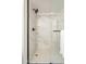 Close up of glass shower with marble tile walls and black hardware at 12946 W Maplewood Dr, Sun City West, AZ 85375