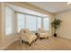 Cozy sun room highlighted by large windows and comfortable chairs and natural lighting at 12946 W Maplewood Dr, Sun City West, AZ 85375